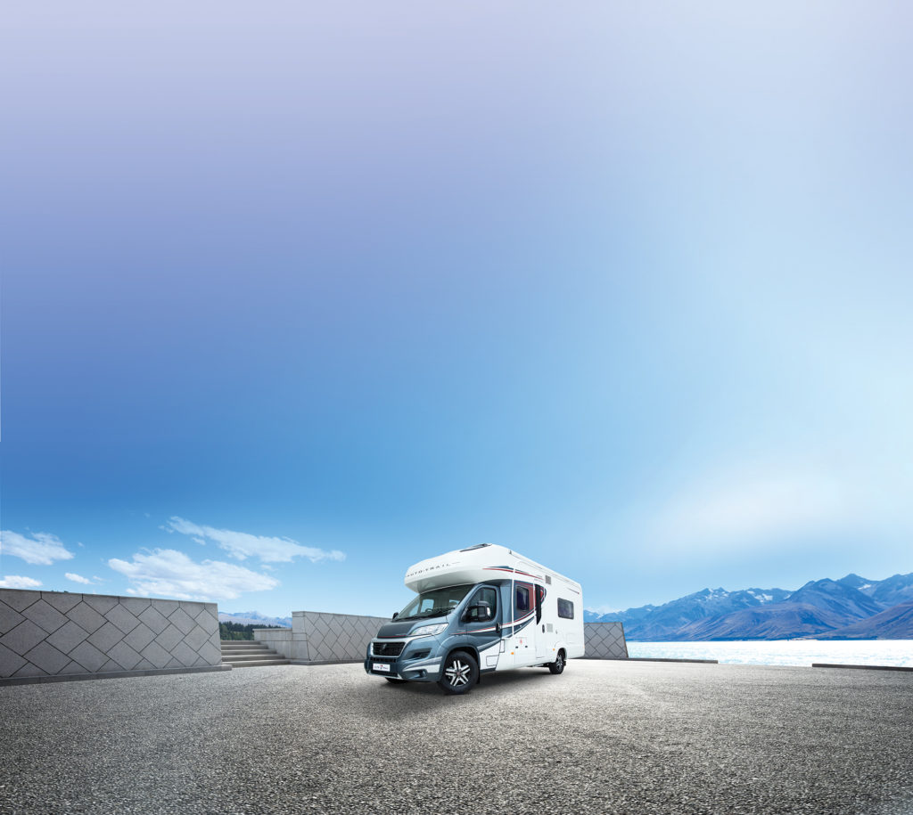 landscape of blue sea from empty road with motorhome on it